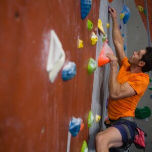 Man wall climbing in gym