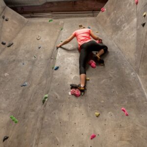young woman exercising at indoor climbing gym